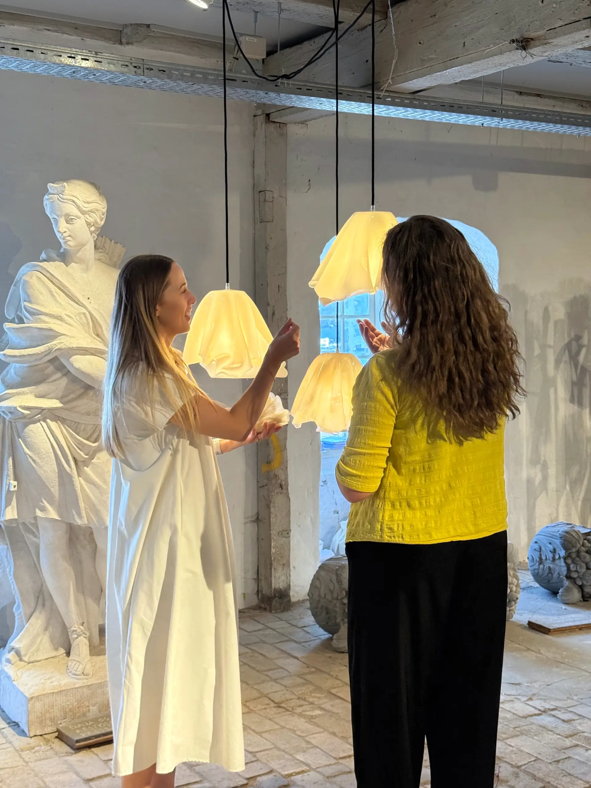 Emilie of Waves.Studio showcasing three artistic pendant lights