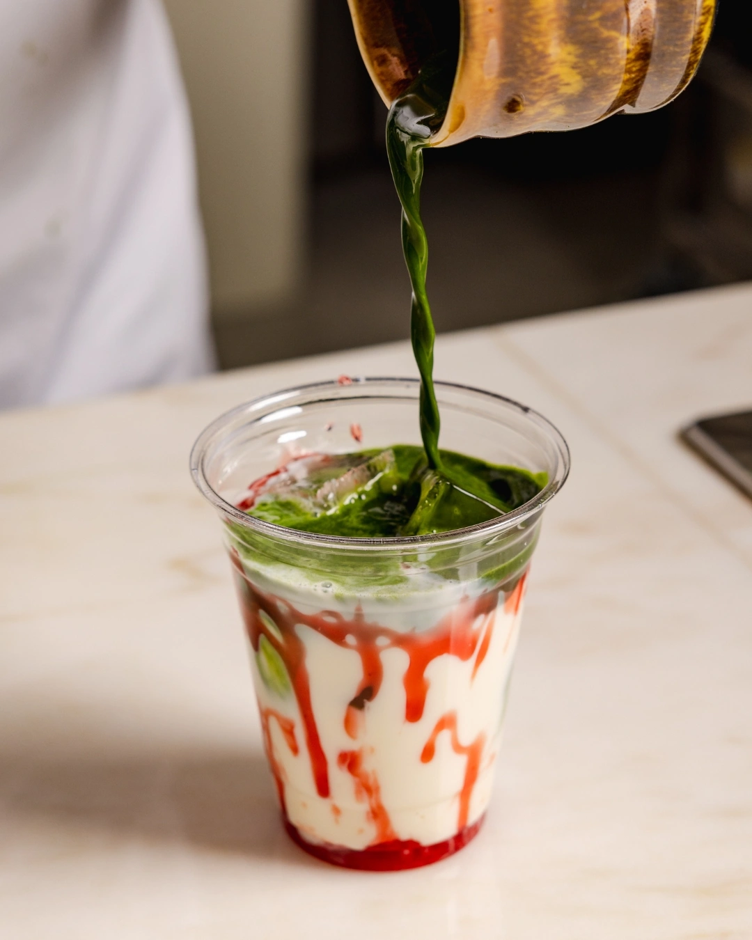 pouring matcha onto iced cloud matcha strawberry drink